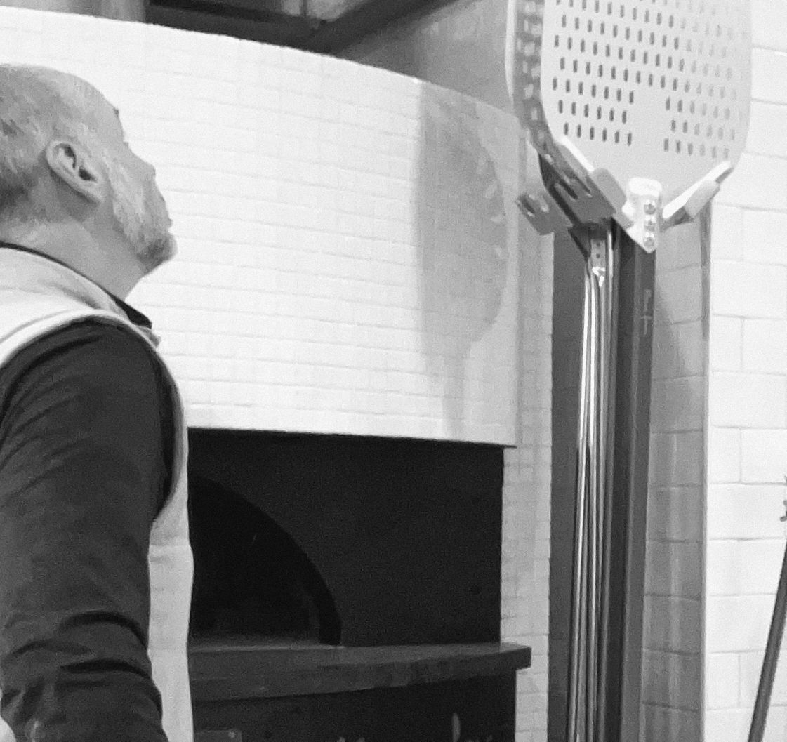 Dave McCabe beside a new pizza oven during a build-out